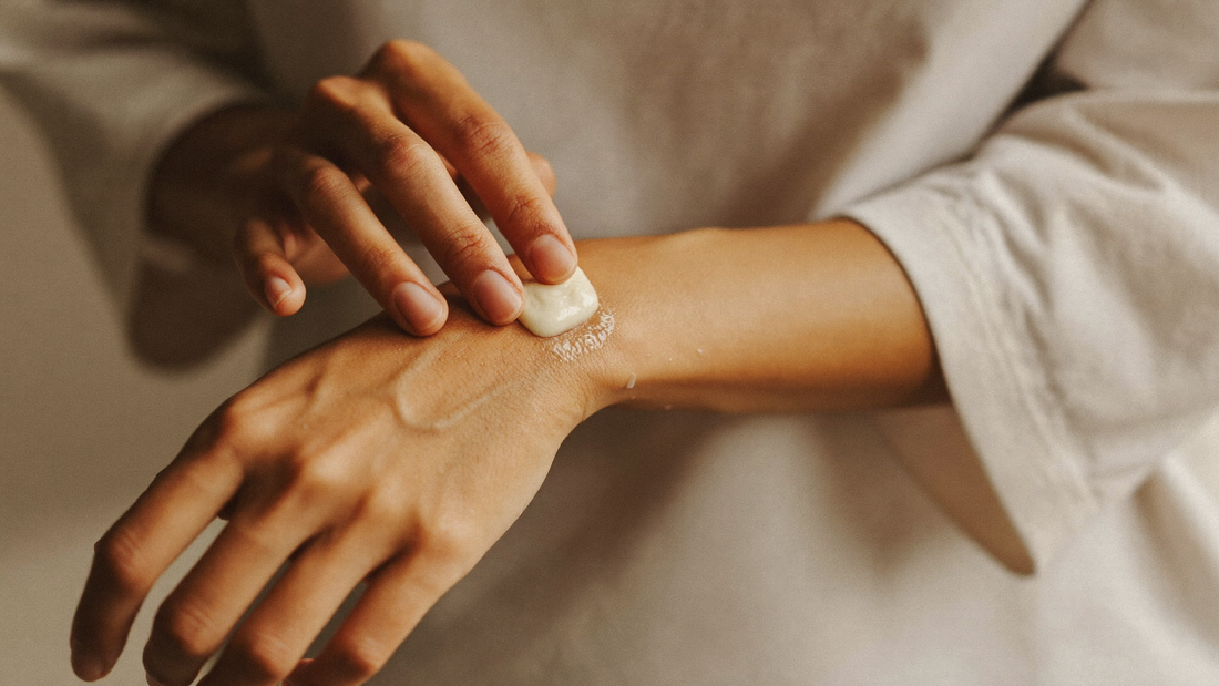 Hands applying a natural balm to the inner forearm for eczema relief